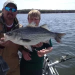 father and son with a large striper caught from fishing trip in nashville given from a gift certificate